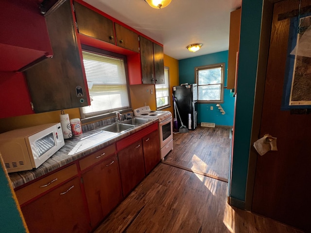 kitchen with white appliances, tile countertops, dark wood-type flooring, and sink