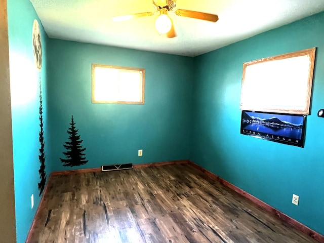 spare room featuring ceiling fan and dark wood-type flooring