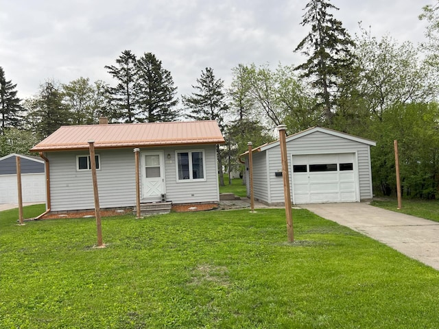 single story home with a garage, an outbuilding, and a front yard