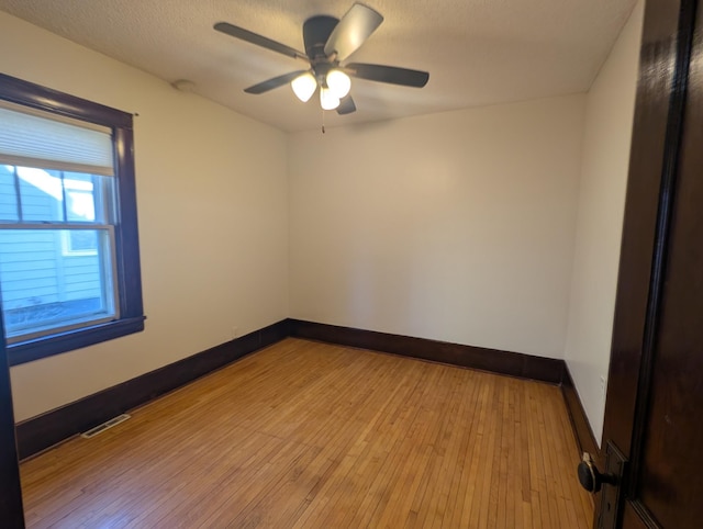 empty room featuring ceiling fan, a textured ceiling, and light wood-type flooring