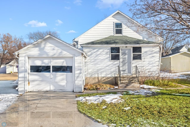 bungalow-style house with a garage and an outdoor structure