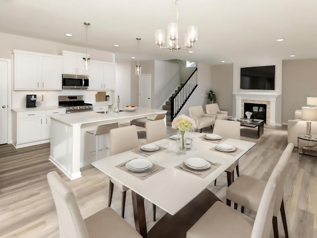 dining room with a chandelier, sink, and light wood-type flooring