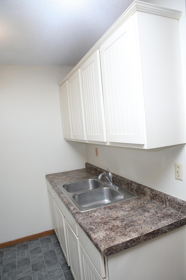 washroom featuring sink and a textured ceiling