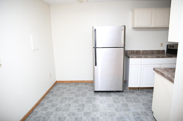 kitchen with white cabinetry and stainless steel refrigerator