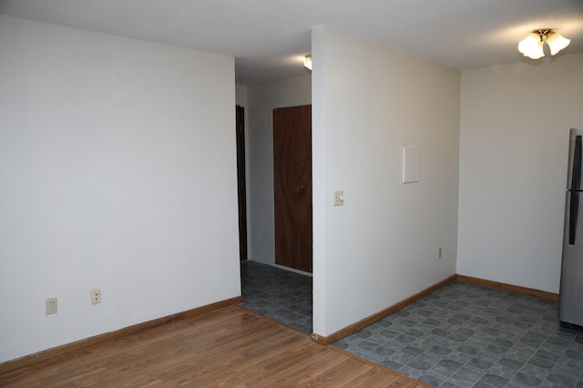 empty room with a textured ceiling and dark wood-type flooring