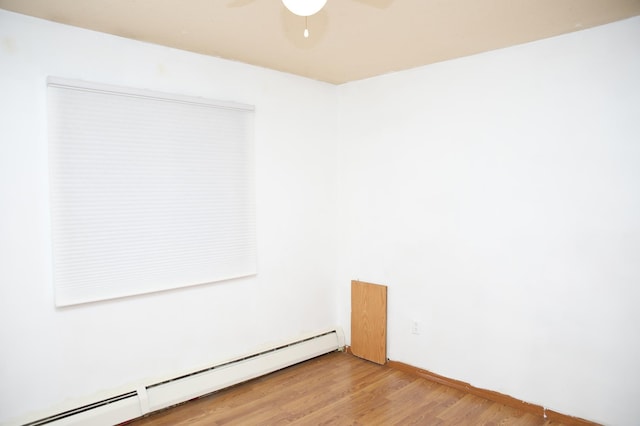 empty room featuring baseboard heating, ceiling fan, and light hardwood / wood-style floors