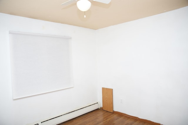 spare room with baseboard heating and hardwood / wood-style flooring