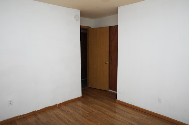 empty room with dark hardwood / wood-style flooring