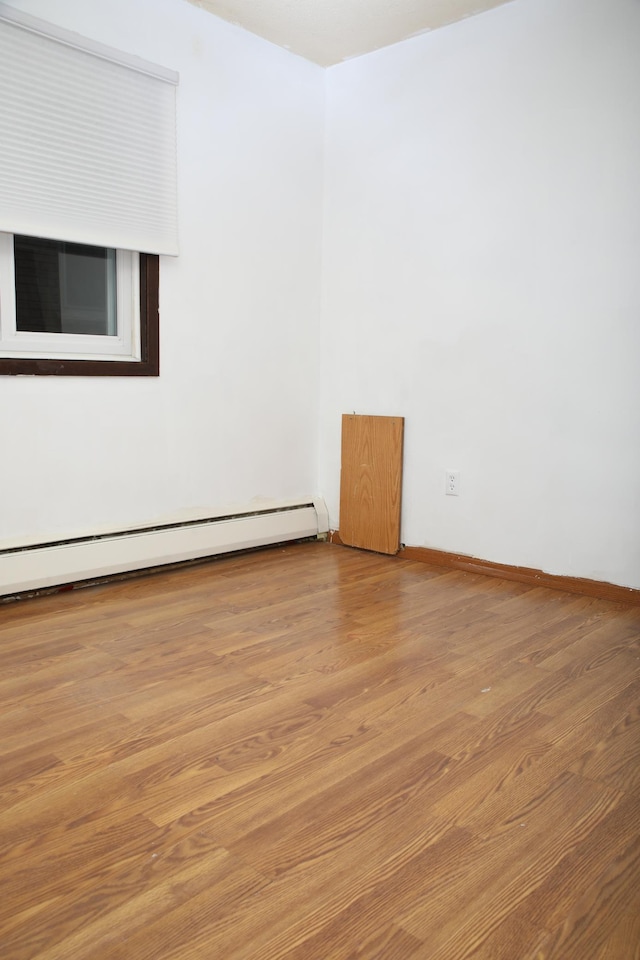 spare room with hardwood / wood-style flooring and baseboard heating