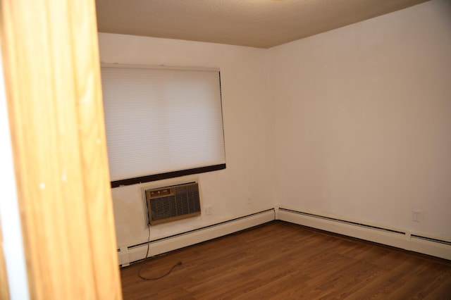 empty room featuring dark hardwood / wood-style flooring and an AC wall unit