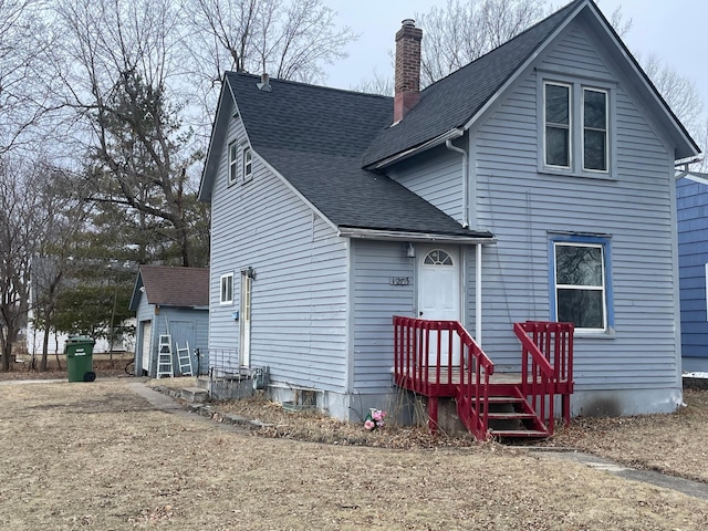 view of front of house featuring a garage and an outbuilding