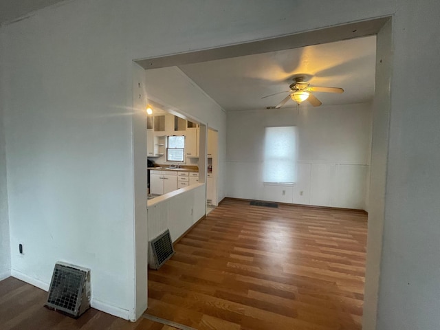 unfurnished living room with ceiling fan and dark wood-type flooring