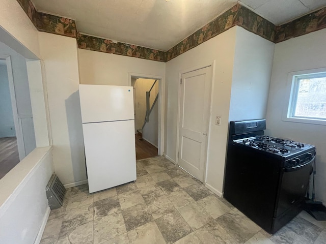 kitchen featuring white fridge and black gas stove