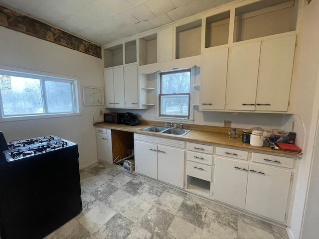 kitchen featuring white cabinetry, sink, and black appliances