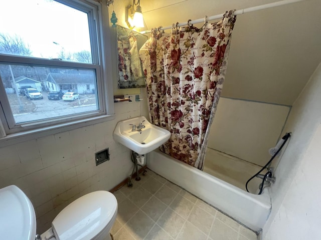 full bathroom featuring toilet, shower / bathtub combination with curtain, and sink