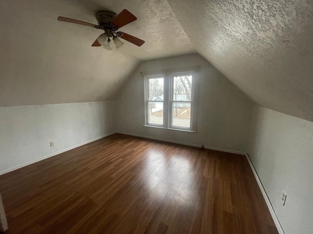 bonus room with a textured ceiling, dark hardwood / wood-style floors, ceiling fan, and lofted ceiling