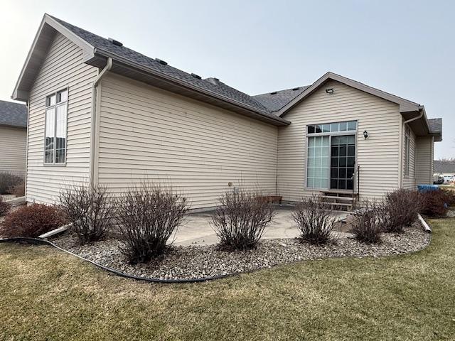 view of property exterior featuring a patio area and a lawn