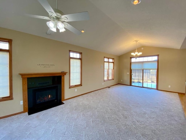 unfurnished living room featuring vaulted ceiling, carpet, and ceiling fan with notable chandelier