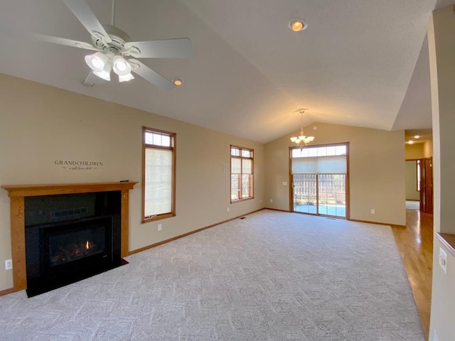 unfurnished living room with vaulted ceiling, light carpet, and ceiling fan with notable chandelier