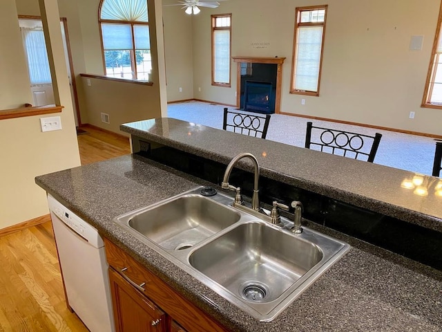 kitchen featuring ceiling fan, sink, white dishwasher, and light hardwood / wood-style floors