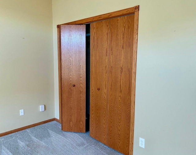 unfurnished bedroom with a closet and light colored carpet