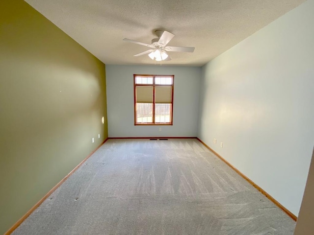 carpeted spare room with ceiling fan and a textured ceiling