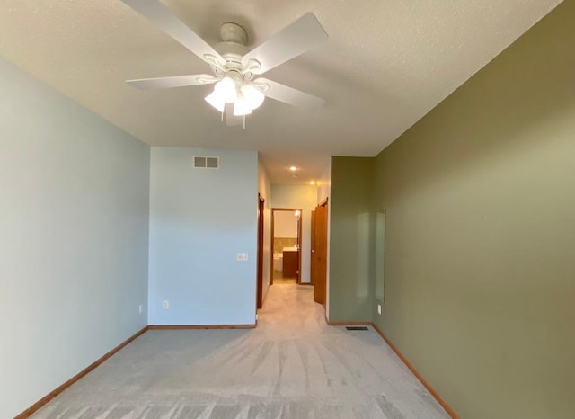 spare room featuring ceiling fan and light colored carpet