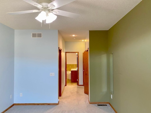 empty room featuring a textured ceiling and ceiling fan