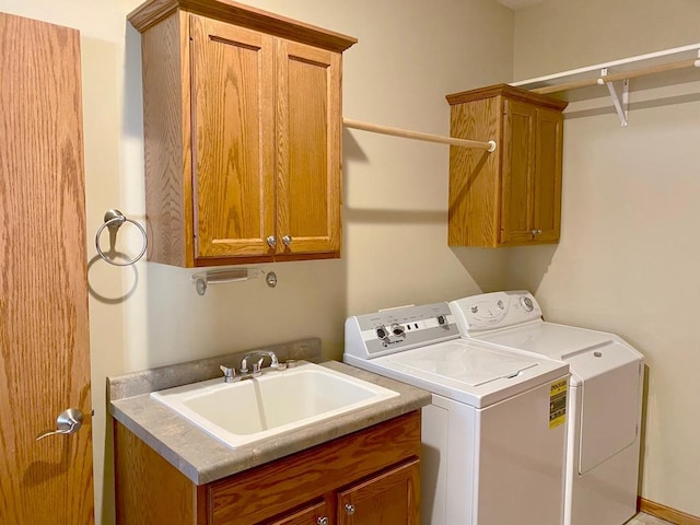 laundry area featuring cabinets, washer and dryer, and sink