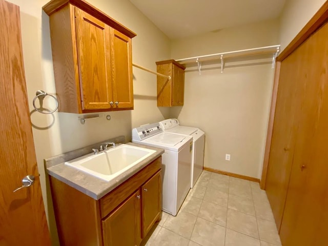 clothes washing area with cabinets, light tile patterned floors, independent washer and dryer, and sink