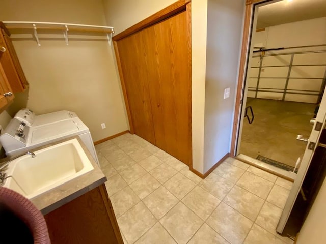 laundry room featuring washer and clothes dryer, sink, and cabinets