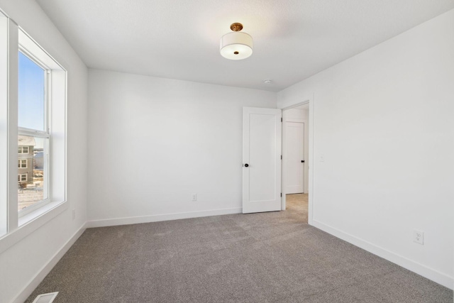 carpeted spare room featuring a healthy amount of sunlight