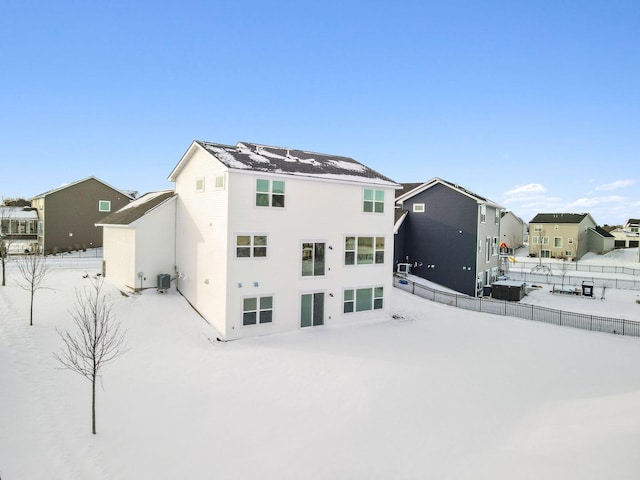 snow covered house with central AC unit