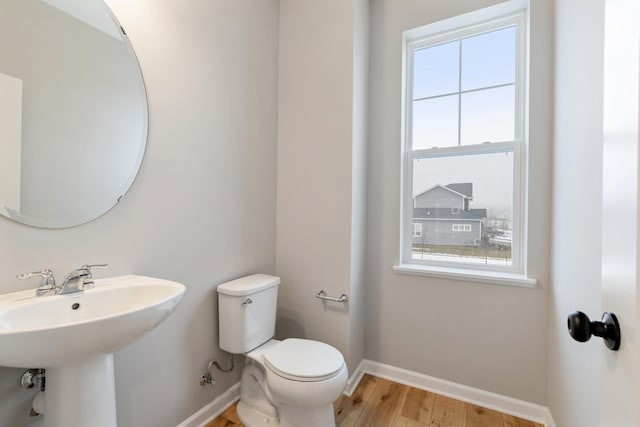 bathroom with hardwood / wood-style flooring, toilet, and sink