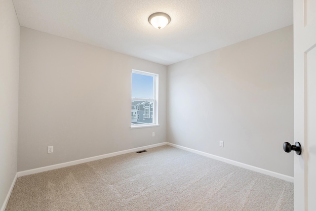 carpeted empty room with a textured ceiling