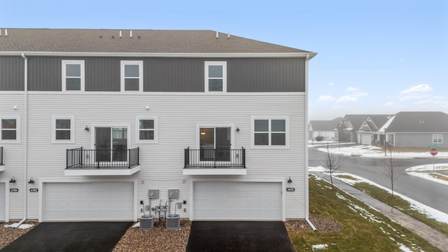 back of house featuring central AC and a garage