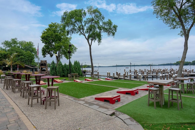 surrounding community featuring a yard, a water view, and a dock