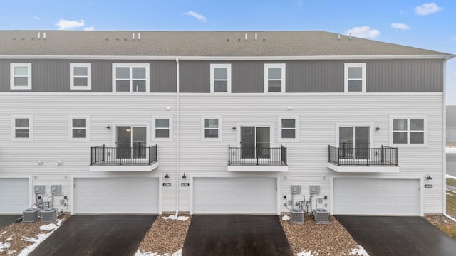 view of front of house with a garage and cooling unit