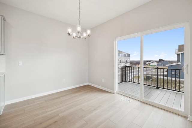 unfurnished room featuring light hardwood / wood-style floors and a chandelier