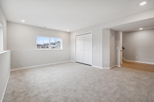 unfurnished bedroom featuring light colored carpet and a closet