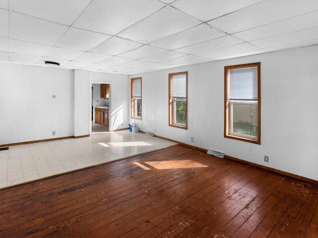 spare room featuring a paneled ceiling and hardwood / wood-style flooring