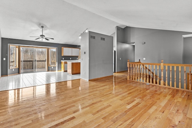 unfurnished living room featuring ceiling fan, light hardwood / wood-style floors, and lofted ceiling