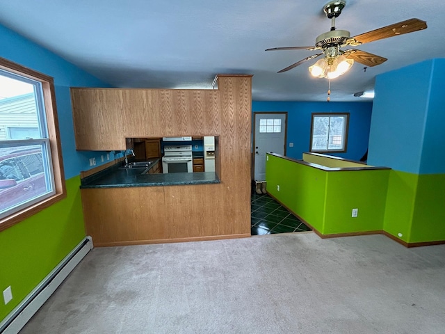 kitchen featuring a healthy amount of sunlight, sink, a baseboard radiator, and dark colored carpet