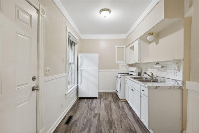 kitchen featuring decorative backsplash, white appliances, sink, dark hardwood / wood-style floors, and white cabinetry