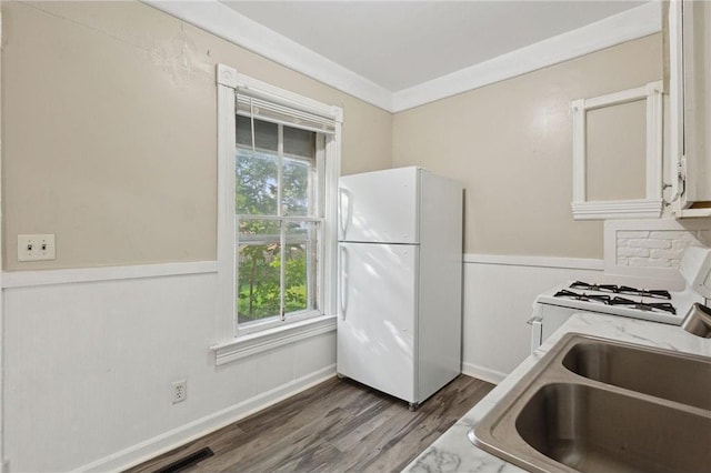 kitchen featuring sink, dark hardwood / wood-style flooring, white appliances, white cabinets, and ornamental molding