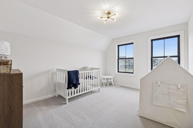 bedroom featuring light carpet, a nursery area, lofted ceiling, and a notable chandelier