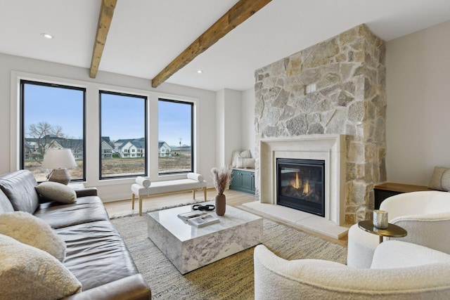 living room with a fireplace, beam ceiling, and hardwood / wood-style floors