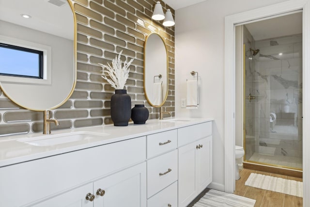 bathroom featuring vanity, hardwood / wood-style flooring, toilet, and a shower with door