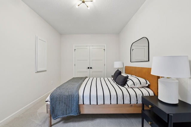 bedroom featuring carpet flooring, a textured ceiling, and a closet