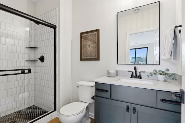 bathroom with vanity, toilet, and a shower with door